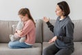 Unhappy sad millennial caucasian woman scolding offended teen daughter with toy