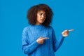 Unhappy sad and timid, insecure lovely african-american pretty woman with afro haircut in winter sweater, sighing uneasy Royalty Free Stock Photo