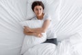 Unhappy sad upset european young woman hugging pillow, suffering from pain and loneliness, lying on bed Royalty Free Stock Photo