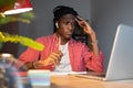 Young African man freelancer feeling tired of monotonous tasks, looking at laptop with upset face Royalty Free Stock Photo