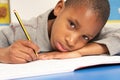 Unhappy Schoolboy Studying In Classroom