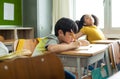 Unhappy Schoolboy studying in classroom at school during lesson, bored and discouraged student. School children education habit Royalty Free Stock Photo