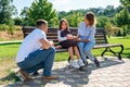 Unhappy schoolgirl sits with parents on a bench and does not want go to school