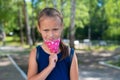 Unhappy schoolgirl takes off her protective mask outdoors. A disgruntled girl does not want to wear a face mask in the