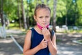 Unhappy schoolgirl takes off her protective mask outdoors. A disgruntled girl does not want to wear a face mask in the