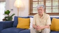 Unhappy senior asian man sitting on sofa in living room, Portrait of dispressed old, elderly asia male at home, retirement people