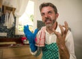 Unhappy and stressed man in kitchen apron feeling frustrated and upset overwhelmed by domestic chores washing dishes tired Royalty Free Stock Photo