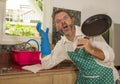 Unhappy and stressed man in kitchen apron feeling frustrated and upset overwhelmed by domestic chores washing dishes tired Royalty Free Stock Photo