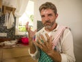 Unhappy and stressed man in kitchen apron feeling frustrated and upset overwhelmed by domestic chores washing dishes tired Royalty Free Stock Photo