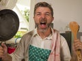 Unhappy and stressed man in kitchen apron feeling frustrated and upset overwhelmed by domestic chores washing dishes tired Royalty Free Stock Photo