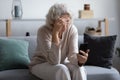 Unhappy stressed mature middle aged woman looking at phone screen Royalty Free Stock Photo