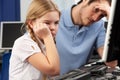 Unhappy teacher and girl using computer in class Royalty Free Stock Photo