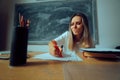 Unhappy Teacher Grading Test Papers in the Classroom Royalty Free Stock Photo