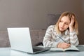 Unhappy teen girl during home online education using laptop. Stress sadness female student do homework classes. Sad woman work Royalty Free Stock Photo