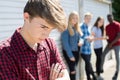 Unhappy Teenage Boy Being Gossiped About By Peers Royalty Free Stock Photo