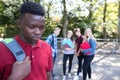 Unhappy Teenage Boy Being Gossiped About By School Friends Royalty Free Stock Photo