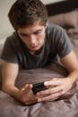 Unhappy Teenage Boy Lying In Bedroom