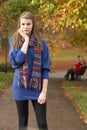 Unhappy Teenage Girl Standing In Autumn Park