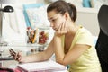 Unhappy Teenage Girl Studying At Desk In Bedroom Looking At Mobile Phone Royalty Free Stock Photo