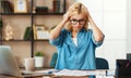 Unhappy tired young business woman in stress at home office working on computer