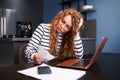 Unhappy woman calculates expenses on bills, upset about increased utilities prices. Female counting paychecks, debts Royalty Free Stock Photo