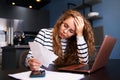 Unhappy woman calculates expenses on bills, upset about increased utilities prices. Female counting paychecks, debts Royalty Free Stock Photo