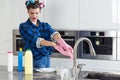 Unhappy woman cleaning big kitchen