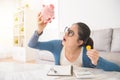 Unhappy woman emptying her piggybank