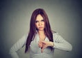 Unhappy woman giving thumbs down gesture looking with negative expression Royalty Free Stock Photo