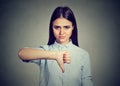Unhappy woman giving thumbs down gesture looking with negative expression Royalty Free Stock Photo
