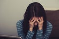 Unhappy woman with headache sitting near the laptop and covering the face the hands. Closeup portrait of business person on work Royalty Free Stock Photo