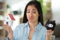 unhappy woman looking at house model and piggybank Royalty Free Stock Photo