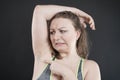 Unhappy woman shows her unshaved armpit. plus size middle age woman is not happy with hair in her armpits. Caucasian girl is Royalty Free Stock Photo