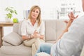 Unhappy woman sitting on couch and talking to therapist Royalty Free Stock Photo