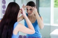 Unhappy woman with skin irritation cleaning her face Royalty Free Stock Photo