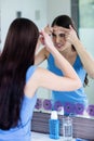 Unhappy woman with skin irritation cleaning her face Royalty Free Stock Photo