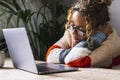 Unhappy woman sleeping on the table in front of an open computer for bad online activity and stress. Tired casual female people Royalty Free Stock Photo