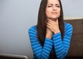 Unhappy woman with throat pain sitting near the laptop and holding the hand the neck. Closeup portrait of business person on work Royalty Free Stock Photo