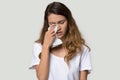 Unhappy young woman holding tissue wiping tears studio shot