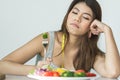 unhappy women is on dieting time looking at broccoli on the fork. girl do not want to eat vegetables and dislike taste of Royalty Free Stock Photo