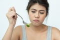 Unhappy women is on dieting time looking at broccoli on the fork. girl do not want to eat vegetables and dislike taste of Royalty Free Stock Photo