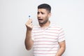 Unhappy worry sick young adult man in white t-shirt standing and holding and looking to thermometer are shoched for high Royalty Free Stock Photo