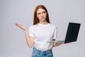 Unhappy young business woman or student holding keeping opened laptop computer and looking at camera Royalty Free Stock Photo