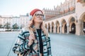 Unhappy young caucasian woman stressed standing at street of old town, using headphones spending time outdoors. Royalty Free Stock Photo