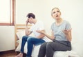 Unhappy young couple arguing, offended affronted woman ignoring angry man sitting her back to jealous husband shouting at