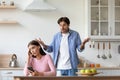 Unhappy young european lady with smartphone ignores offended angry screaming man at kitchen Royalty Free Stock Photo