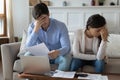 Unhappy young family couple feeling stressed about banking debt.