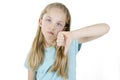 Unhappy young girl giving thumbs down gesture looking with negative expression and disapproval. studio shot Royalty Free Stock Photo