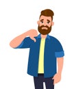 Unhappy young man showing thumbs down sign gesture. Dislike, disagree, disappointment, disapprove, no deal concept. Royalty Free Stock Photo