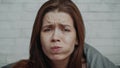 Unhappy Young Woman Eating Burger Looking At Camera In Bedroom